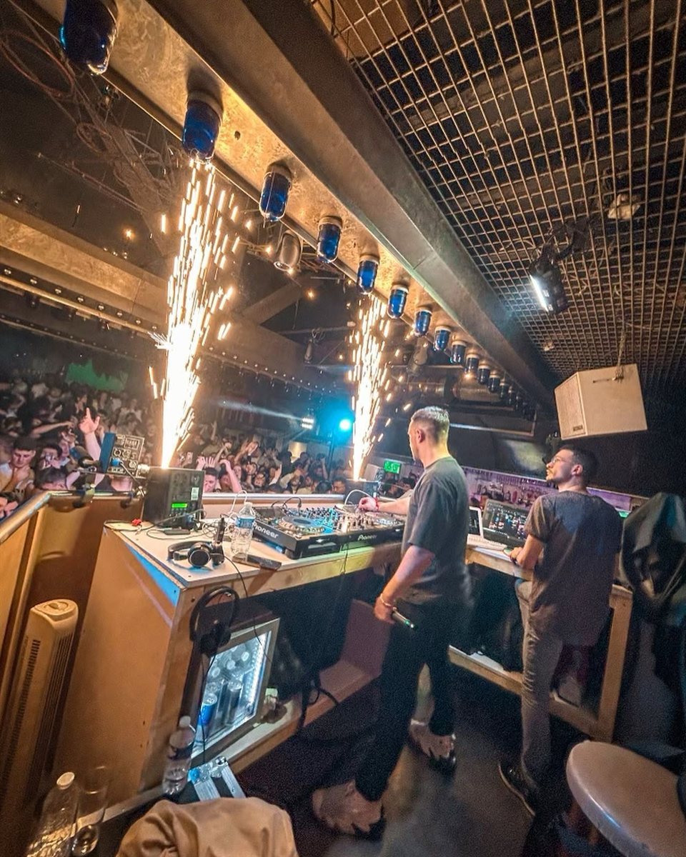 Eliott en DJ set en club, jets d'étincelles au-dessus des platines